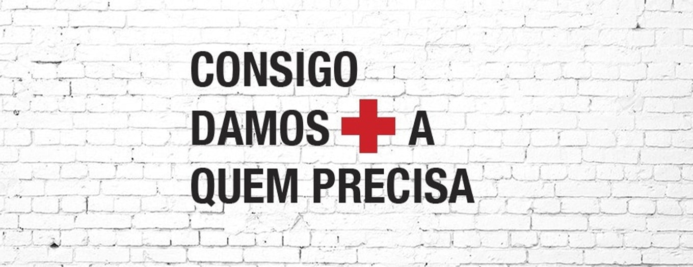 Banner com imagem de fundo a imitar tijolos brancos e com a mensagem “Consigo damos mais a quem precisa”